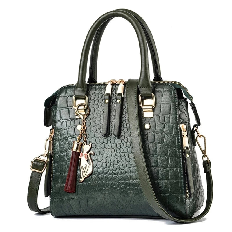 Green textured handbag with gold accents and a tassel on a white background, featuring the brand 'Yogodlns'.