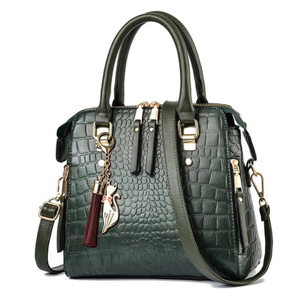 Green textured handbag with gold accents and a tassel on a white background, featuring the brand 'Yogodlns'.