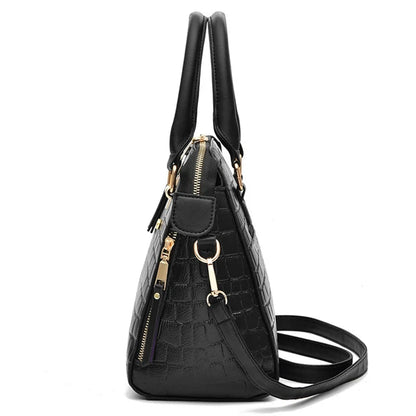 Black handbag with gold accents on a white background, featuring the brand 'Yogodlns'.