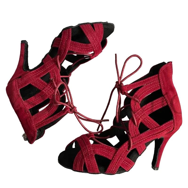 A pair of red strappy high-heeled sandals with cutout details and lace-up fronts, displayed on a striped fabric background. The brand name 'YSWEOYOMIC' is visible in the top left corner.