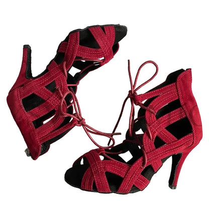 A pair of red strappy high-heeled sandals with cutout details and lace-up fronts, displayed on a striped fabric background. The brand name 'YSWEOYOMIC' is visible in the top left corner.