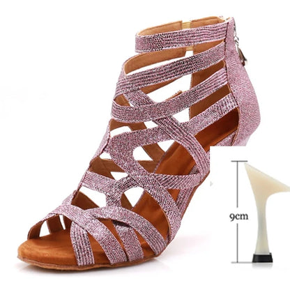 A pink glittery strappy high-heeled sandal with an ankle strap and open toe, shown on a white background with a small inset diagram indicating a 9 cm heel height.