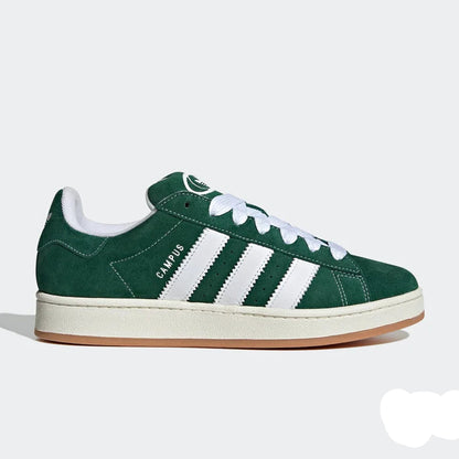 Green Adidas sneaker with white stripes on a light gray background