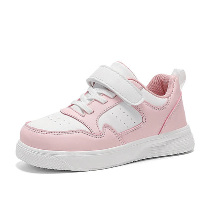 A pink and white low-top sneaker with a hook-and-loop strap closure, white laces, and a thick white sole, shown from a side profile on a white background.