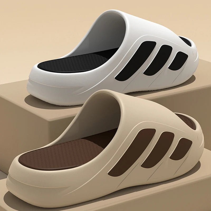 White and beige slides with black soles on a beige background