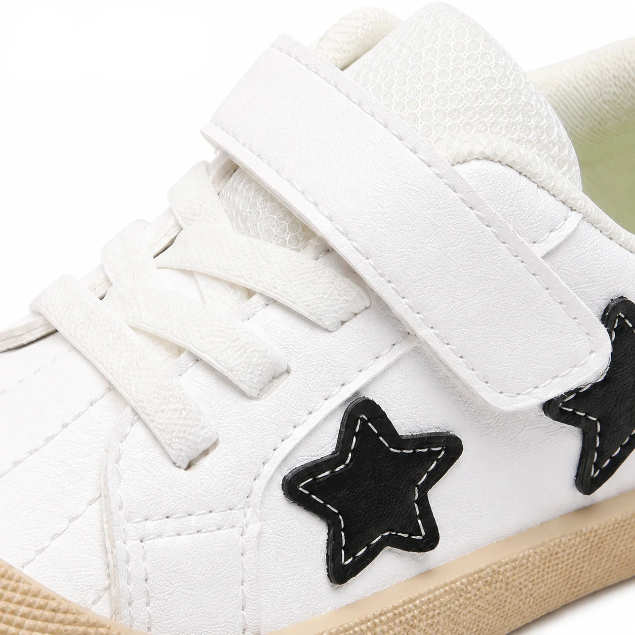 White low-top sneaker with a hook-and-loop strap closure, white laces, black star-shaped side patches, and a beige rubber sole. PmwRun logo appears in the top-left corner.