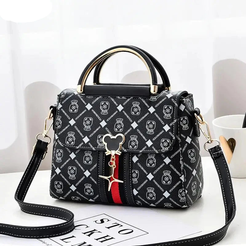 Black patterned handbag with a strap on a white surface, featuring the brand 'YSHKY'.