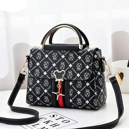 Black patterned handbag with a strap on a white surface, featuring the brand 'YSHKY'.