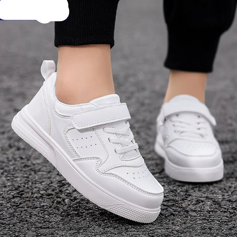 White low-top sneakers with hook-and-loop straps and thick white soles, shown being worn on a person's feet on a gray textured ground. The NBGAGA brand logo is visible in the top-left corner.