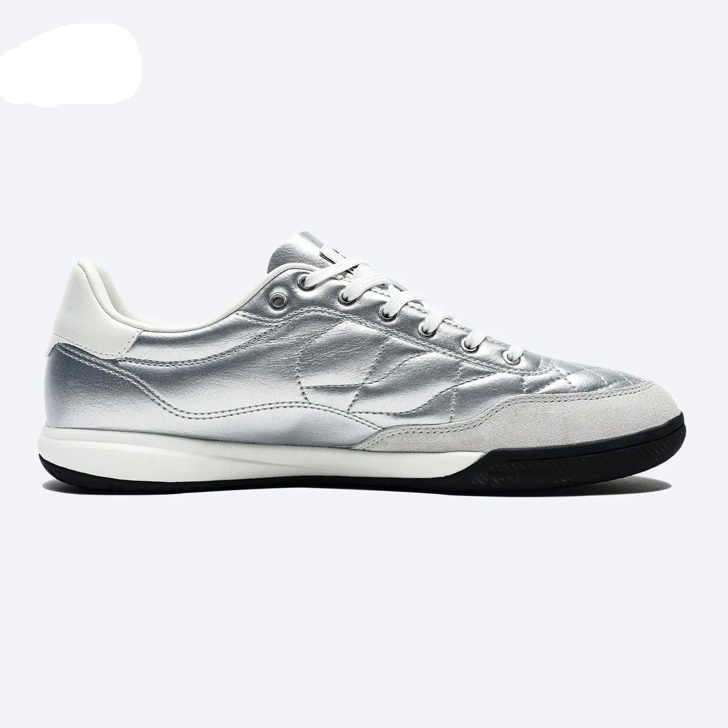 A silver and white low-top sneaker by KELME, featuring a metallic silver upper, white laces, a white midsole, and a black outsole, shown from a side profile on a light gray background.