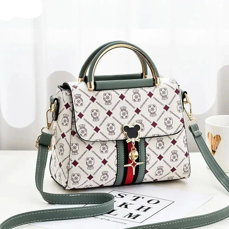 Designer handbag with patterned design and Mickey Mouse charm on a white surface.