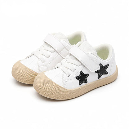 A pair of children's white low-top sneakers with beige rubber toe caps and soles, featuring black star-shaped side accents and hook-and-loop straps. The brand name 'PmwRun' is displayed in blue in the top-left corner.