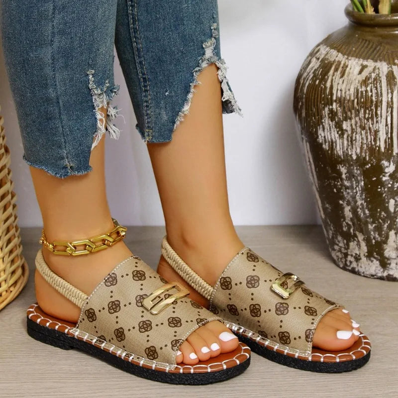 Beige patterned sandals worn with ripped jeans on a neutral background
