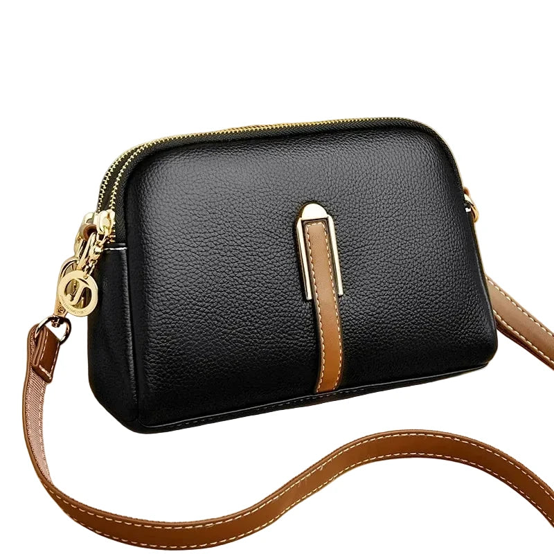 Black pebbled leather crossbody bag with a brown leather accent strap and gold-tone hardware, shown on a beige background with promotional text in the top left corner.