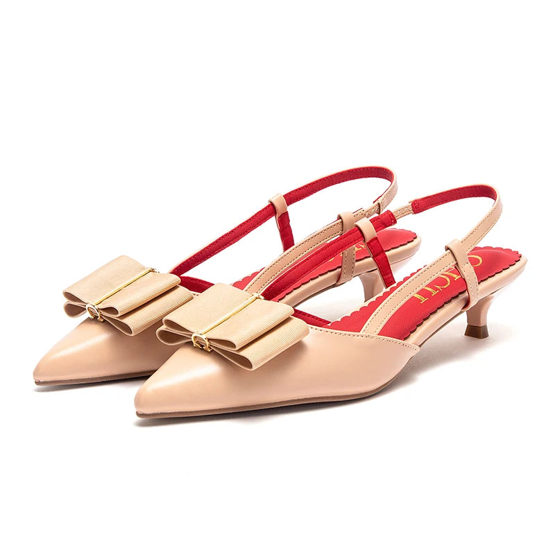 Beige high heels with red interior and gold bows on a white background