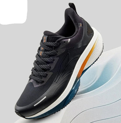 A 361° athletic sneaker in black and dark gray with a thick white midsole and orange accents, shown on a light gray background with a white curved platform.